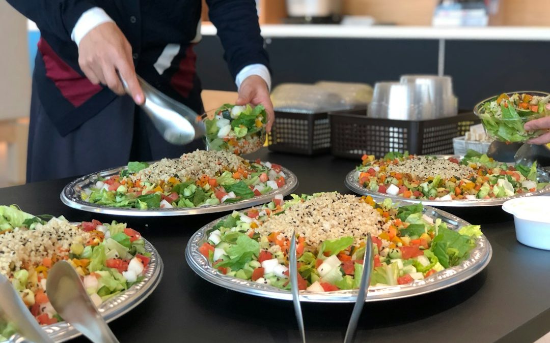 Servicio de catering de empresa con ensalada y menú de mediodía en una oficina de Barcelona